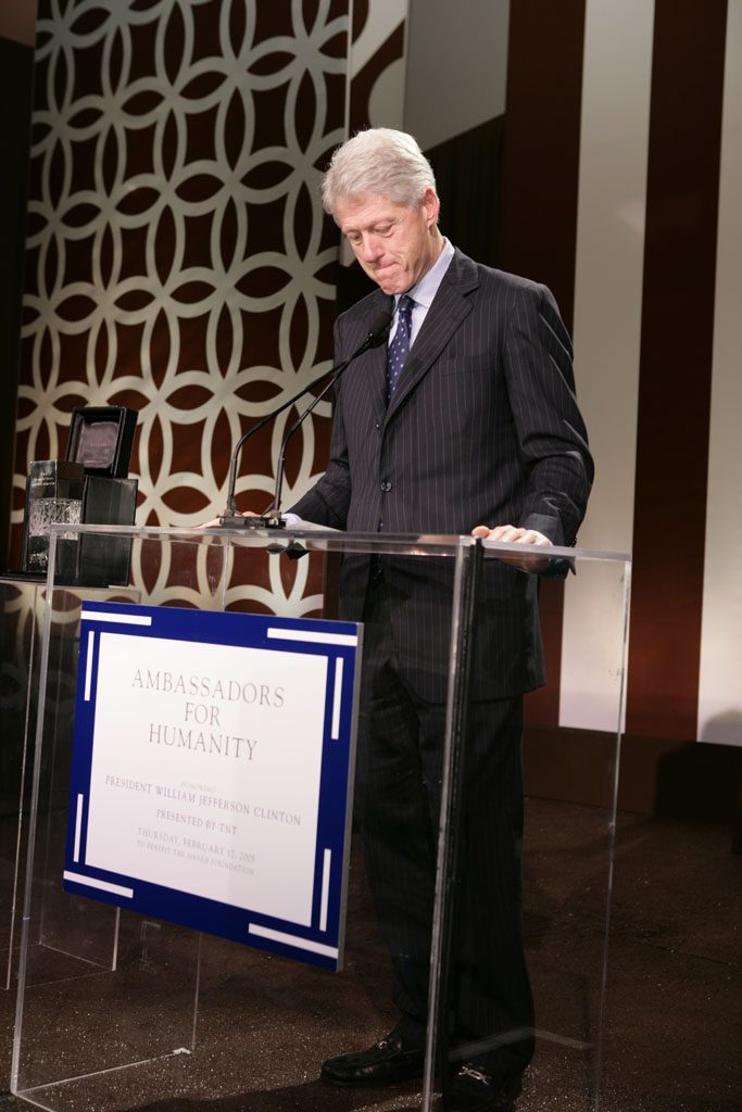 A man standing at a podium with a sign.