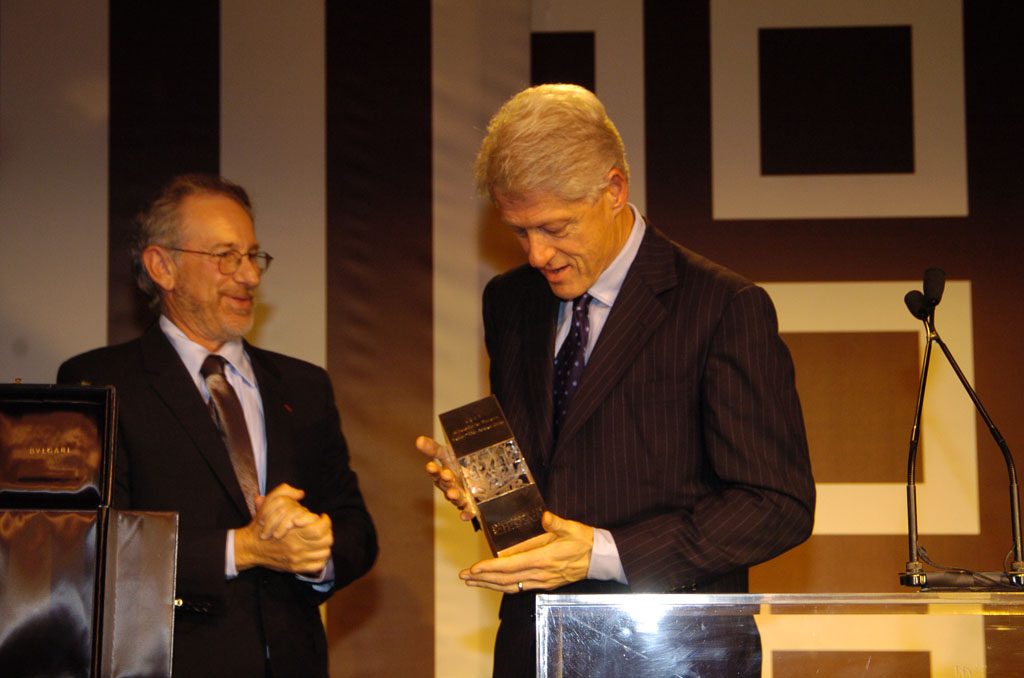 A man in suit and tie holding an electronic device.