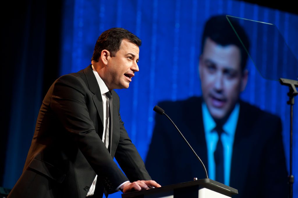 A man in suit and tie speaking at a podium.