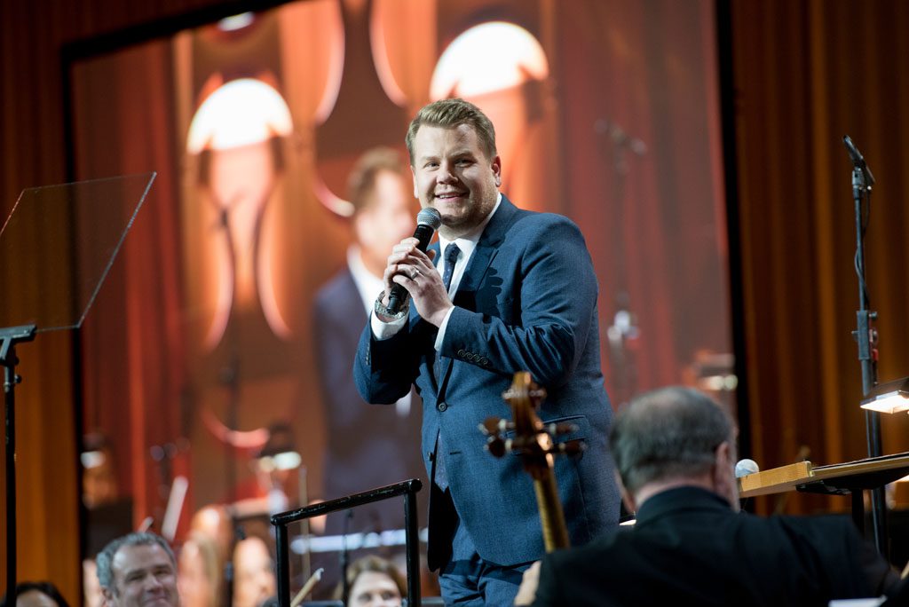 A man in a suit and tie holding a microphone.