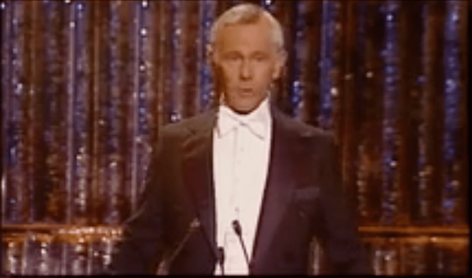 A man in a tuxedo is standing at the podium.