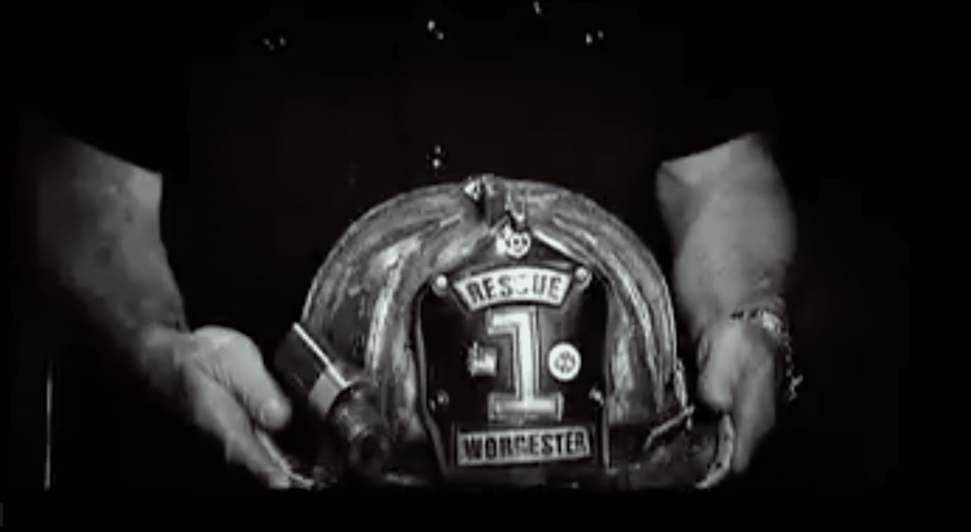 A person holding a fire helmet in their hands.